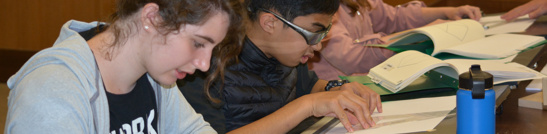 Blind students in a classroom setting reviewing STEM materials