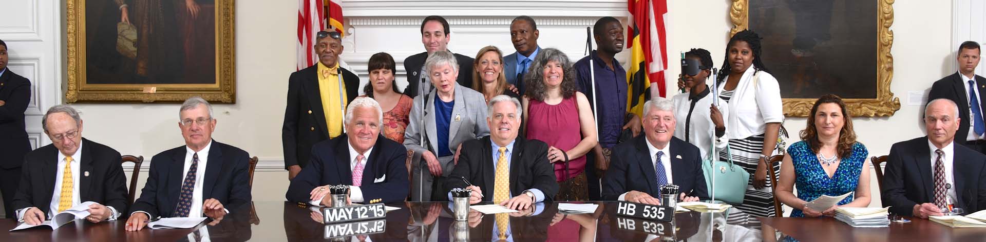 NFB of Maryland members stand behind Governor Larry Hogan as he signs a HB 535